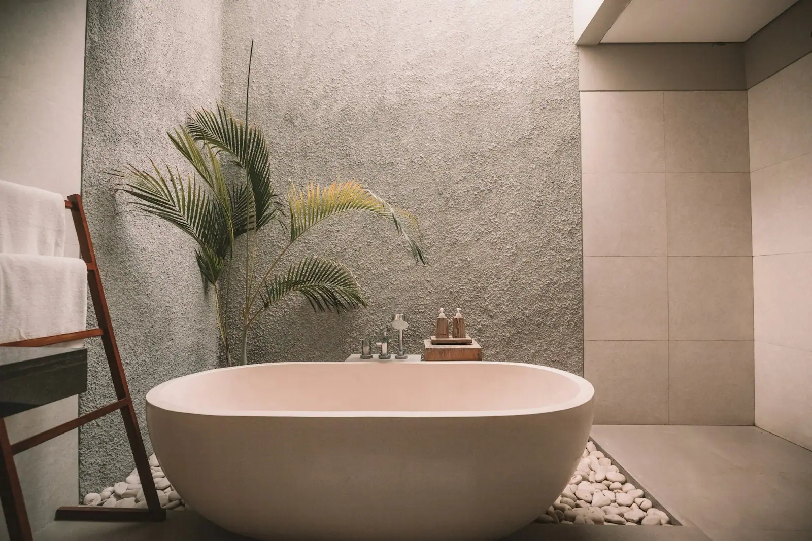Freestanding soaking tub against a textured plaster wall
