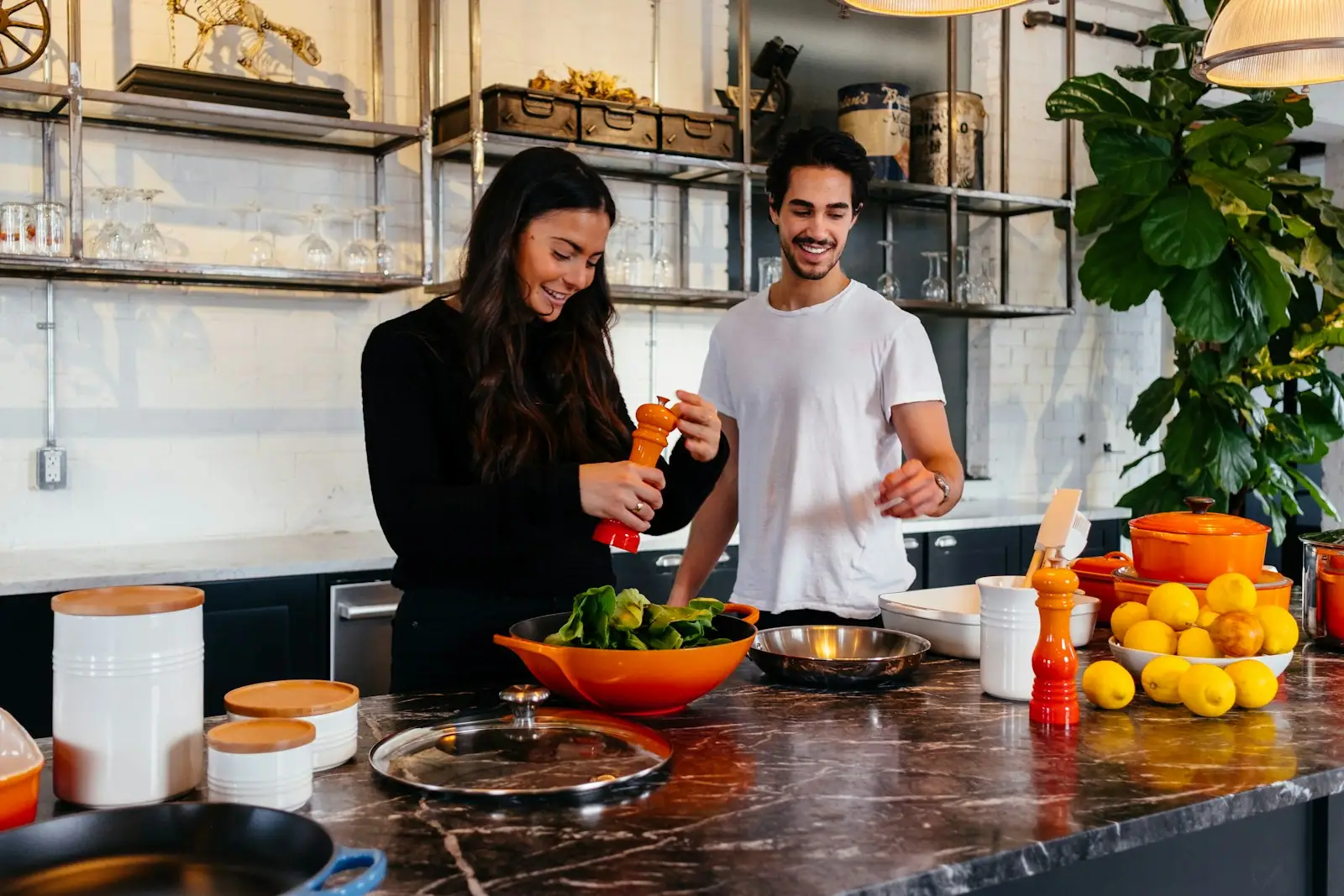 Couple cooking together at a dark stone kitchen island