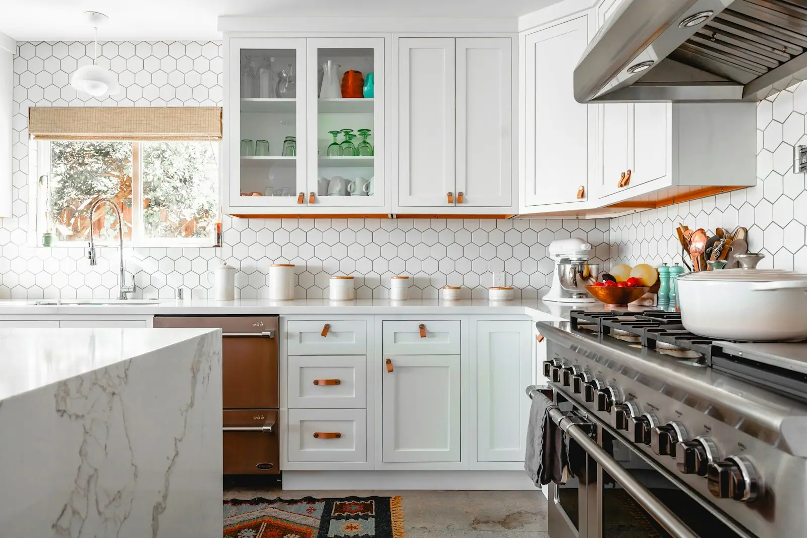 Kitchen with hexagon tile backsplash, range hood and quartz counters