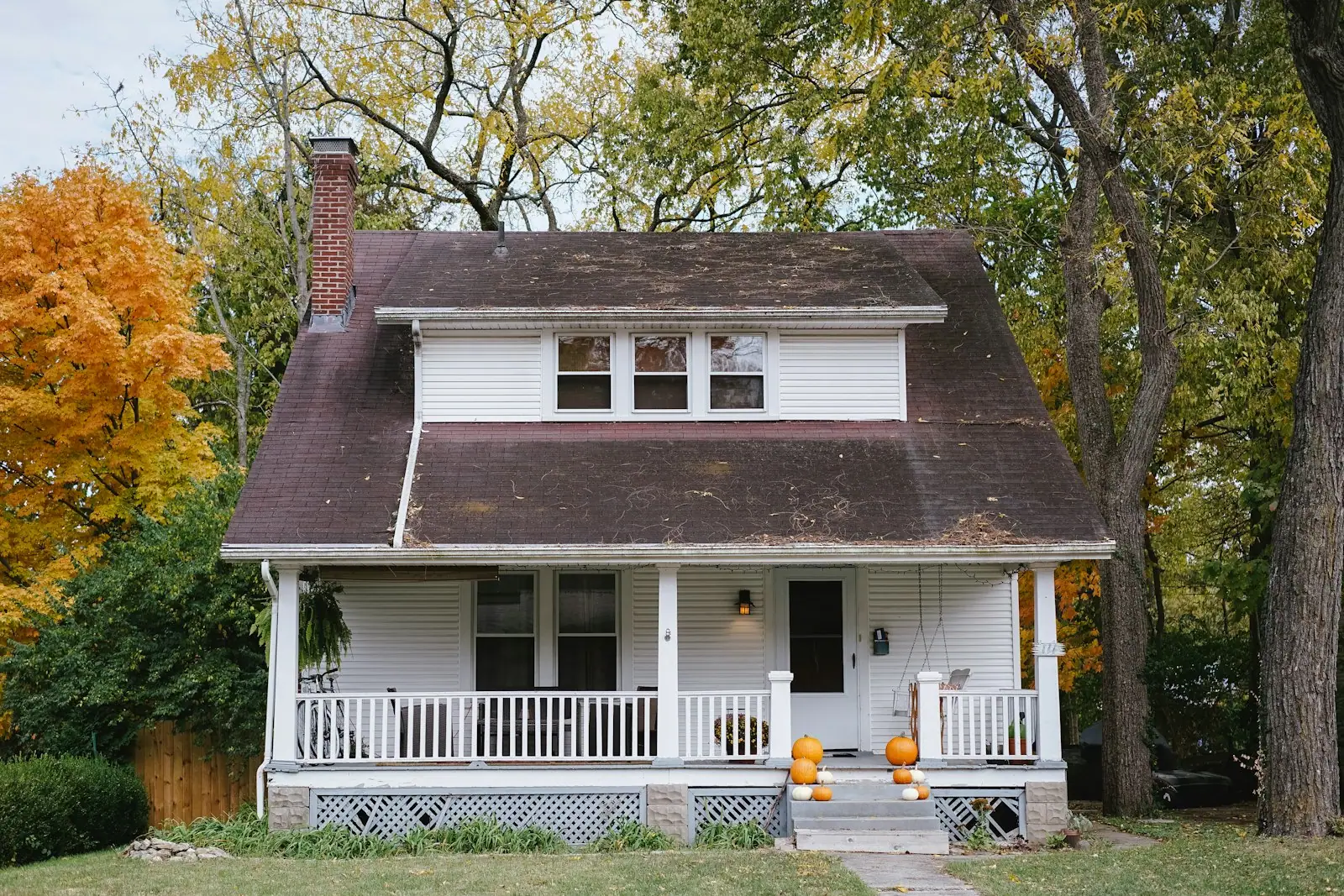 Early-1900s bungalow with a front porch in fall