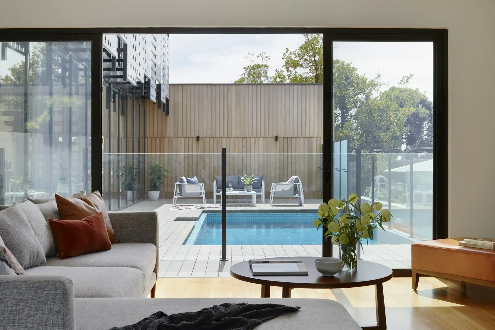 Living room addition with glass doors opening to a pool terrace