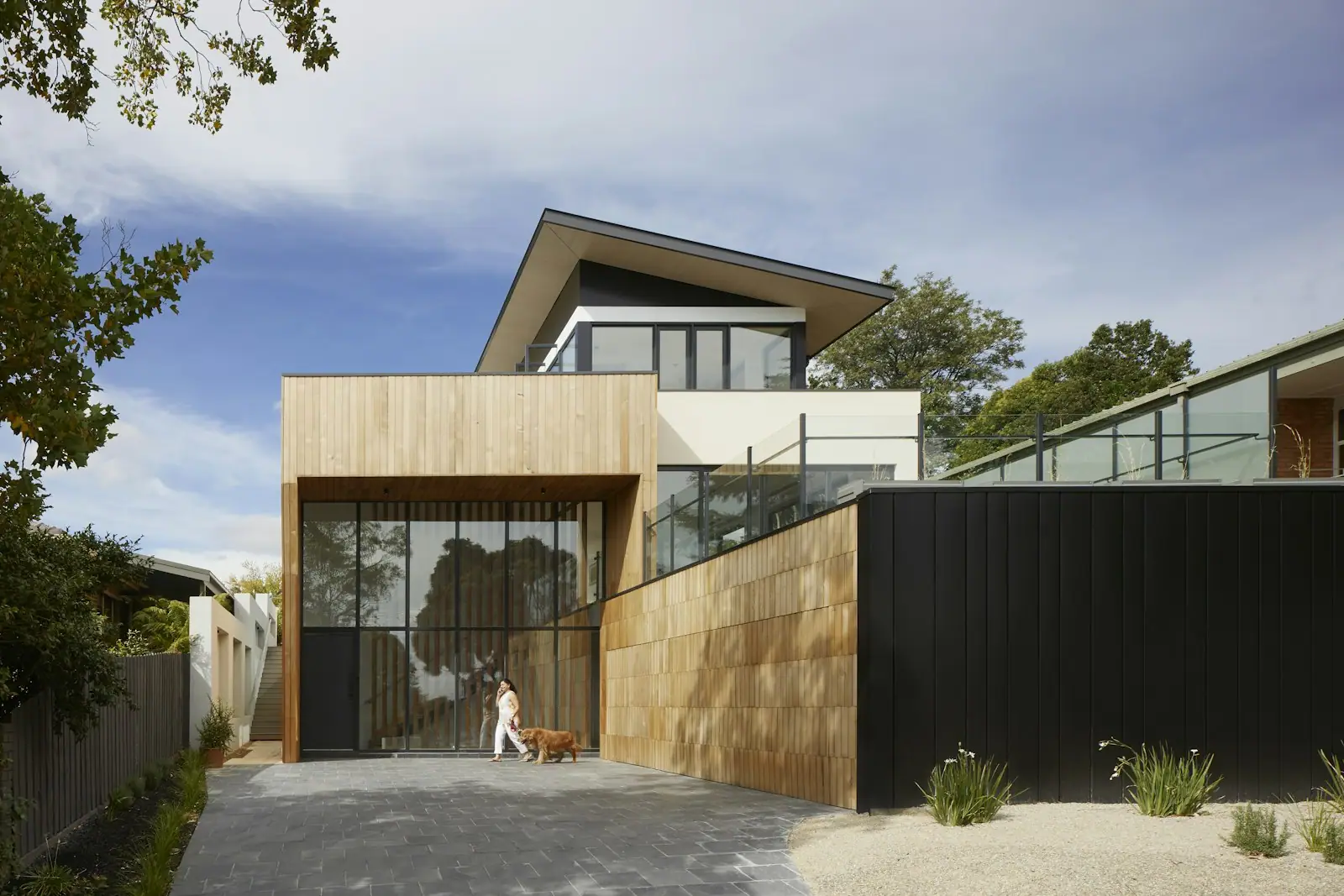 Two-story addition with a timber and glass facade