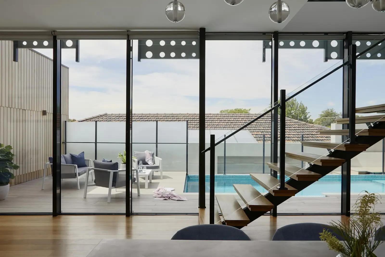 Living room with a floating stair and glass walls