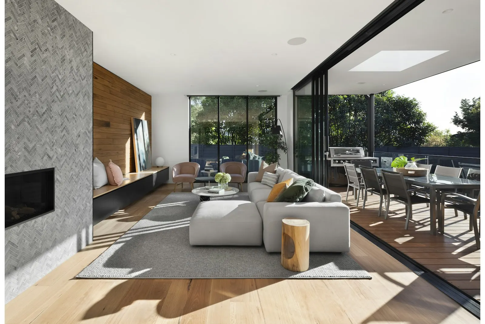 Open living room with a stone fireplace and sliding doors to a terrace