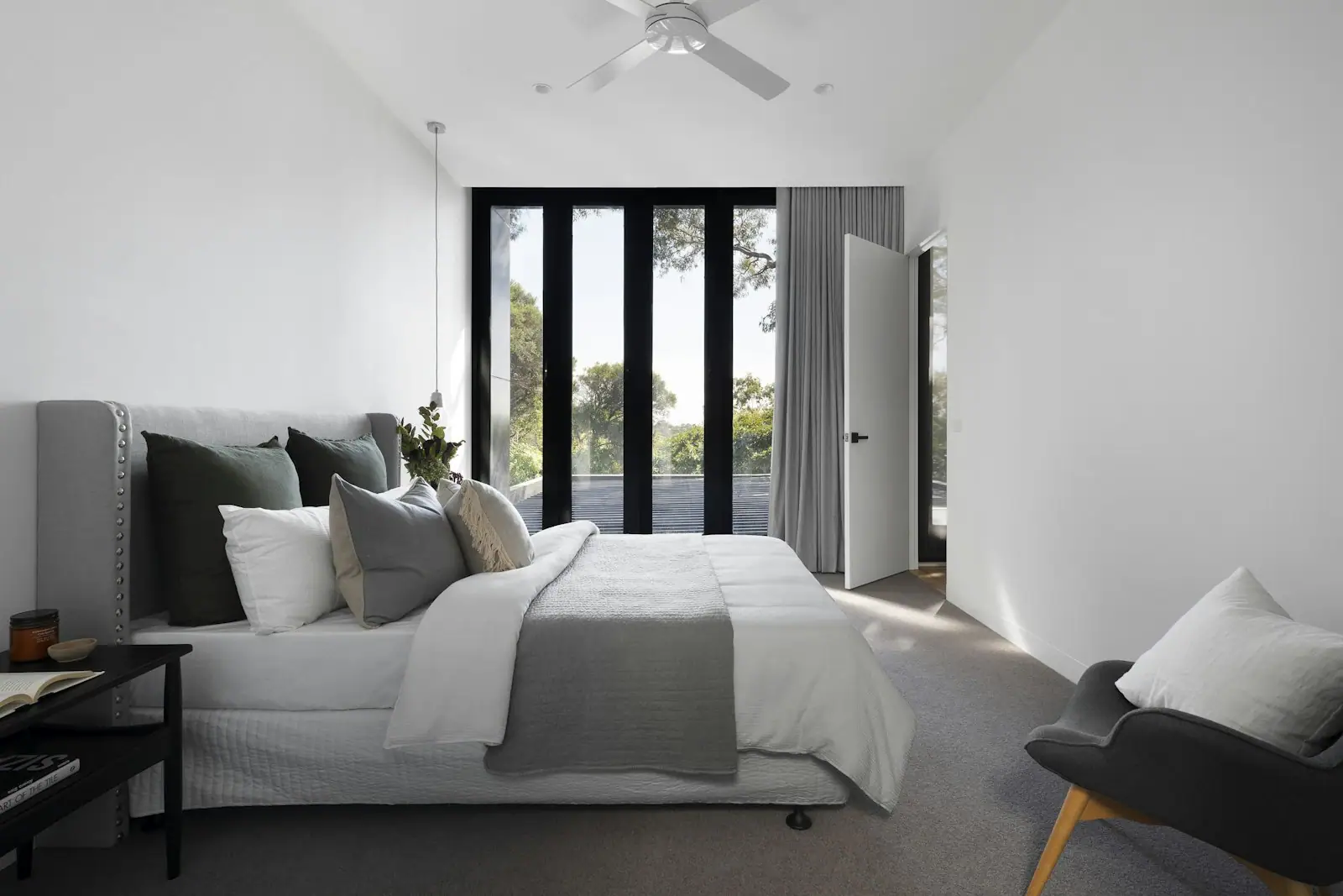 Primary bedroom with black-framed doors to a garden