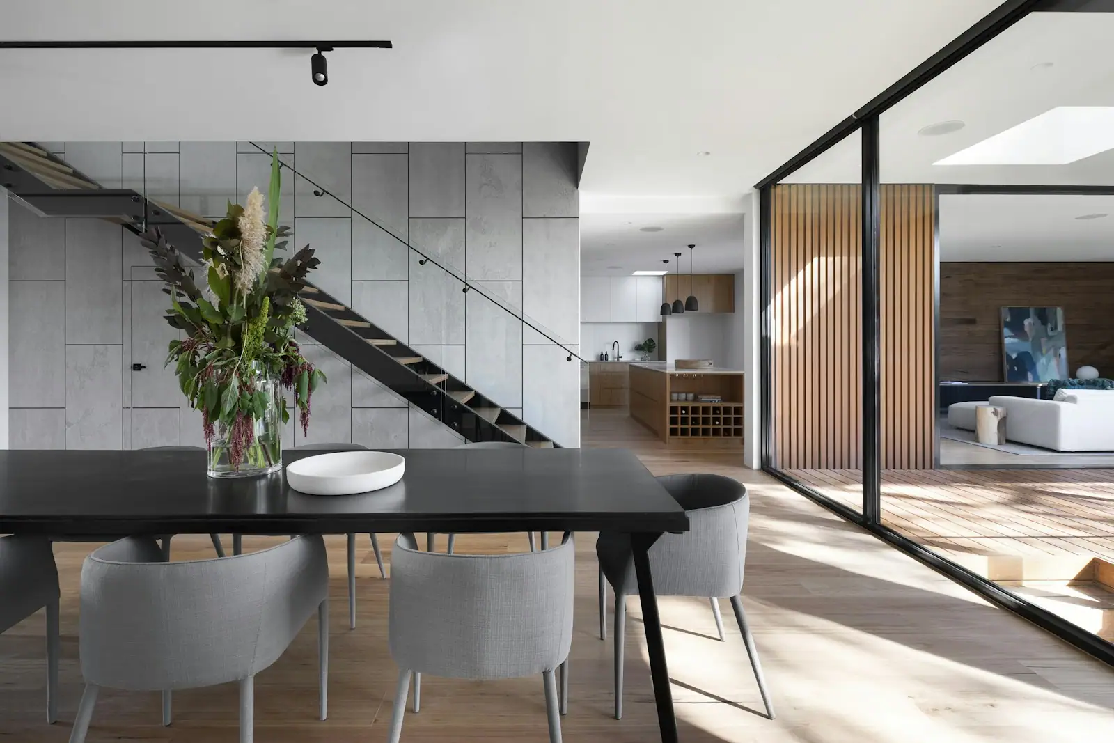 Dining room with a black table beside a floating stair