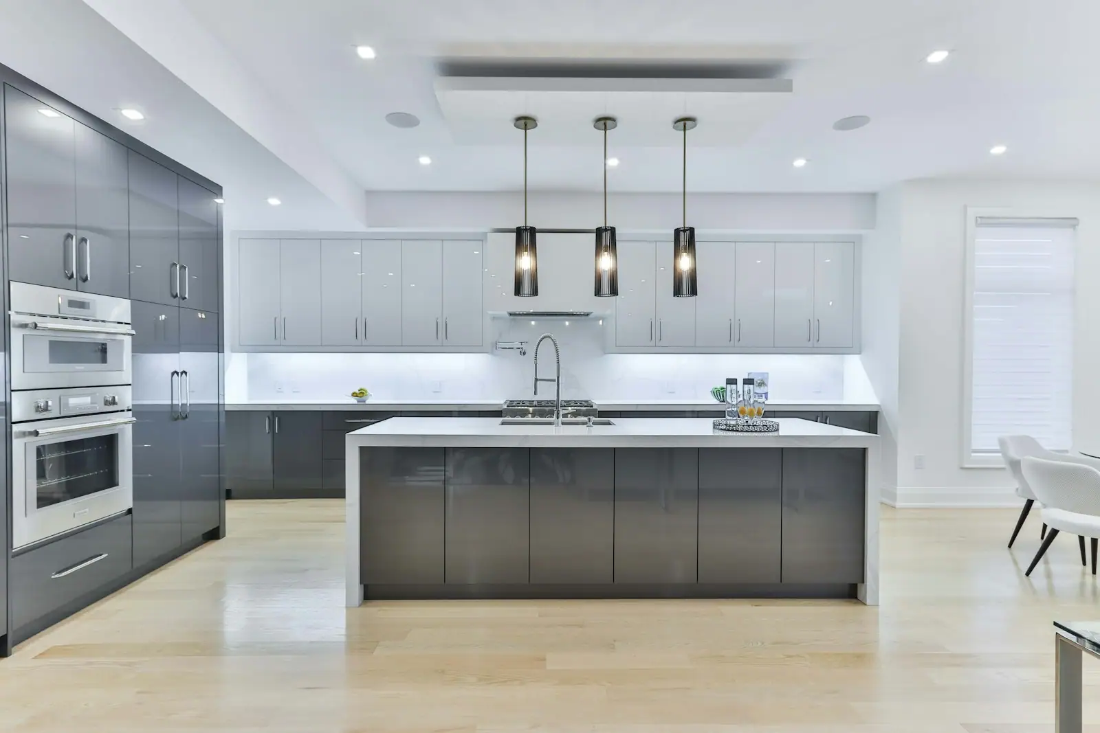 Large kitchen with gray cabinetry, a long island and three pendants