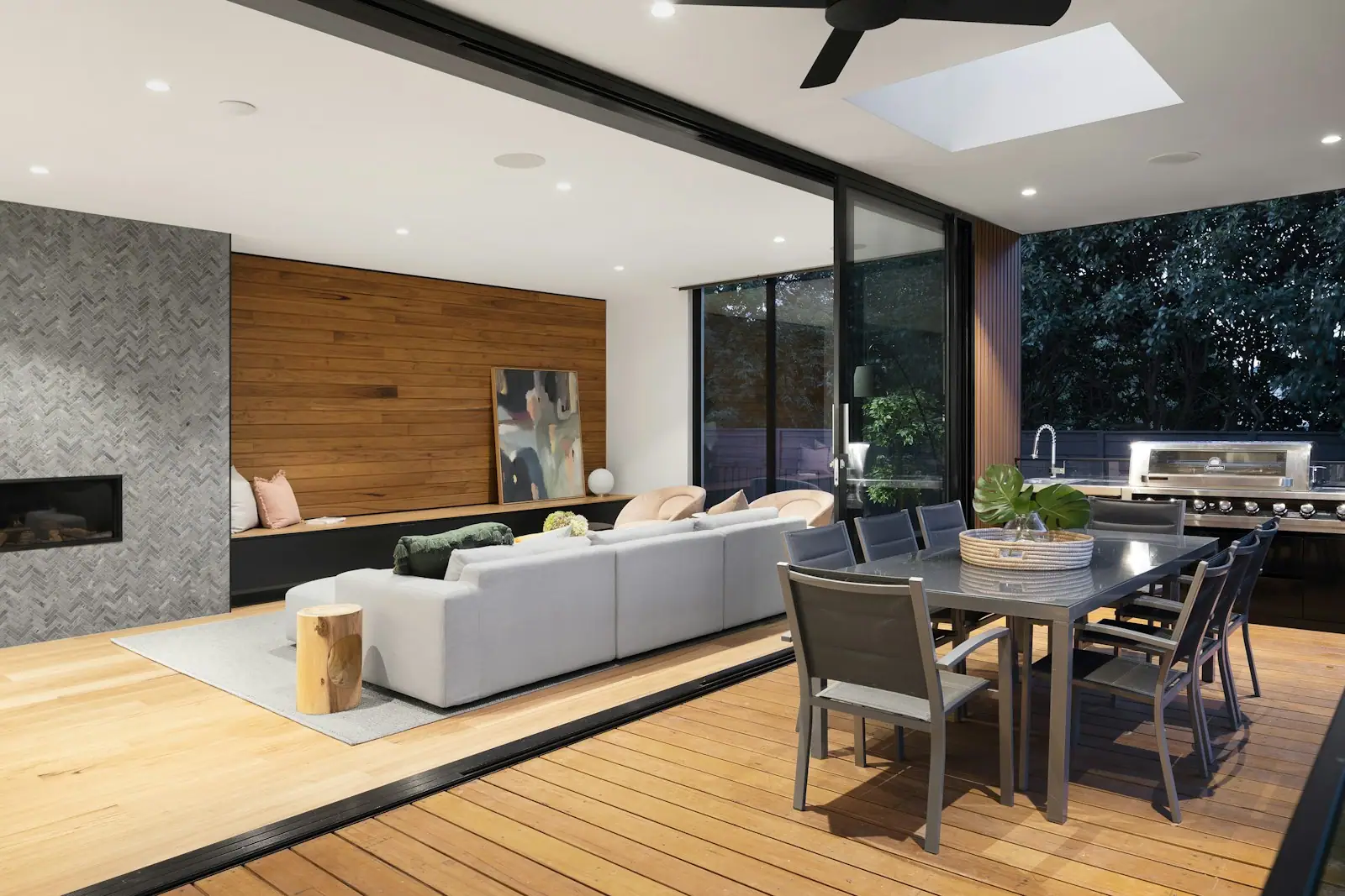 Open dining and living space with a fireplace and skylight